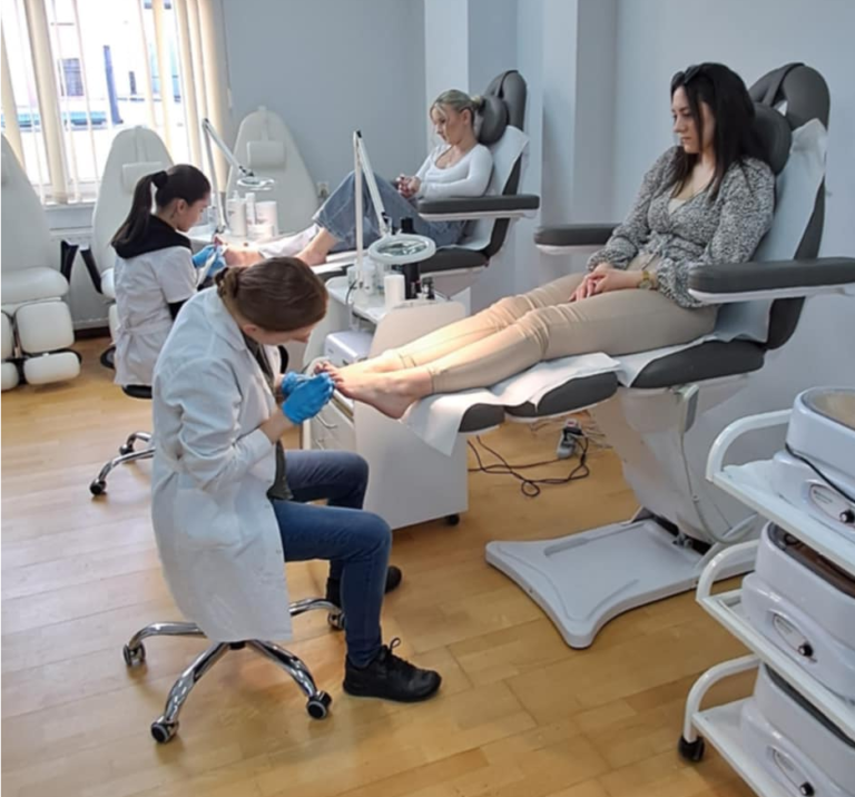 Zdjęcie przedstawia osoby wykonujące zabiegi podologiczne.